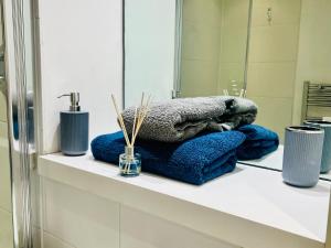 a bathroom counter with towels and a mirror at Modern Canary studio- Wifi in London