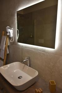een witte wastafel in een badkamer met een spiegel bij Masseria Tenuta Flora Maria in Leverano