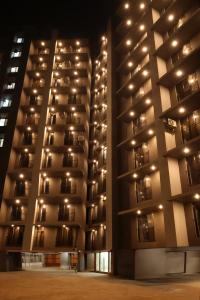 ein großes Apartmenthaus in der Nacht mit eingeschaltetem Licht in der Unterkunft Axon Aleta in Mumbai