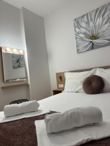 a bedroom with a white bed with two towels on it at Apartmani Samec in Novalja