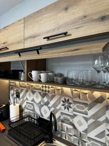 una cucina con bancone, bicchieri e lavandino di JP Luxury Apartment in citycenter a Xánthi
