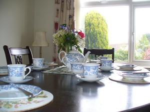 a dining room table with blue and white cups and saucers at 14 Links Way in West Runton