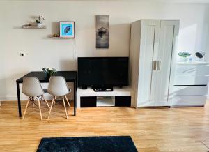 Modern Canary studio- Wifi في لندن: غرفة معيشة فيها تلفزيون وطاولة وكراسي