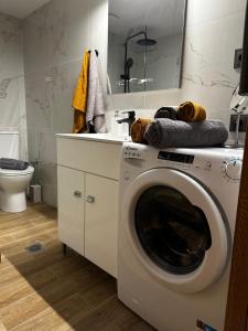 y baño con aseo y lavadora. en JP Luxury Apartment in citycenter, en Xanthi