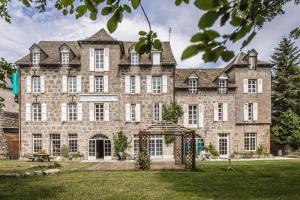 uma grande casa de pedra com um grande quintal em Résidence thermale La Chaldette em Brion