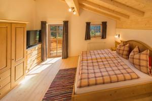 Schlafzimmer mit einem Bett und einem Flachbild-TV in der Unterkunft Wald am See in Kitzbühel