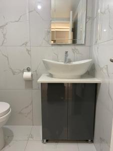 La salle de bains blanche est pourvue d'un lavabo et de toilettes. dans l'établissement Unit 76 Melville Mews, à Johannesbourg