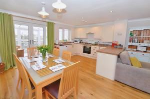 a kitchen and living room with a table and a couch at 18 Marriotts Way in Sheringham