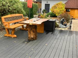 una mesa de picnic de madera y un banco en una terraza en Haus Maisonette am Harz, en Niedersachswerfen