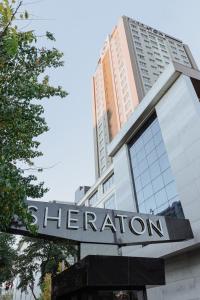 a building with a sign for the sheraton at Sheraton Bishkek in Bishkek