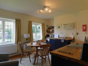 a kitchen and dining room with a table and chairs at Little Lodge in Sheringham