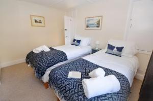 - une chambre avec 2 lits et 2 serviettes dans l'établissement Compass Rose Cottage, à Sheringham