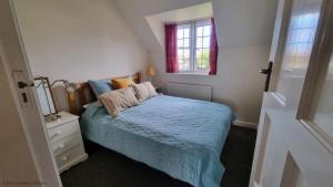 a small bedroom with a bed and a window at Little Lodge in Sheringham