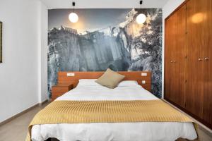 Schlafzimmer mit einem Bett mit Wandgemälde in der Unterkunft GAV La Ermita in Ronda