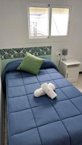 Un dormitorio con una cama azul con una toalla. en Casa típica Andaluza El Lucero, en Rute