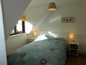 Schlafzimmer mit einem Bett mit blauer Decke in der Unterkunft 23 Chapel Street in Northrepps