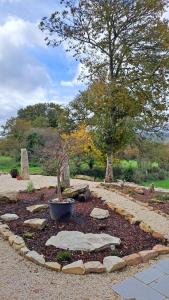 un jardín con rocas, una olla y un árbol en Galician Rural Accommodation - La Casita, en Lugo