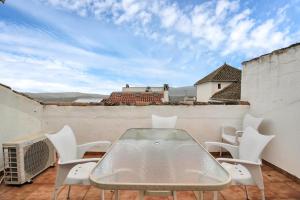 un tavolo e sedie su un balcone con vista di GAV La Ermita a Ronda