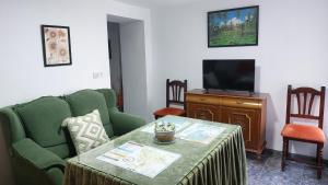 - un salon avec une table et une télévision dans l'établissement Casa típica Andaluza El Lucero, à Rute