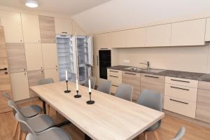 a kitchen with a long wooden table and chairs at Village Loft in Sankt Stefan im Rosental