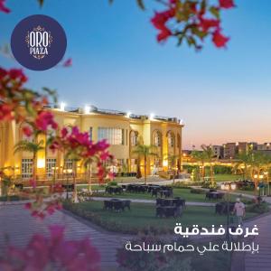 un grand bâtiment avec des fleurs roses devant lui dans l'établissement فندق أورو بلازا ORO Plaza Hotel, au Caire