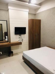 a bedroom with a bed and a tv on a wall at The highland hotel in Bathinda +15 photos