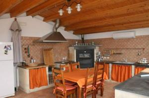 una cucina con tavolo e una cucina con frigorifero di TRAVELLIVING - Casa Vacanze Villa Ida, Beachfront a Punta Braccetto