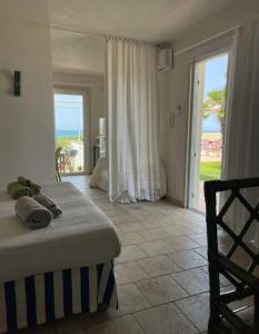 una camera con letto e porta per l'oceano di TRAVELLIVING - Casa Vacanze Villa Ida, Beachfront a Punta Braccetto
