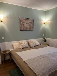 een bed in een kamer met twee kussens erop bij L'Harmony in Saint-Arnoult-en-Yvelines