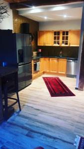 a large kitchen with wooden cabinets and a red rug at Split in Veberöd