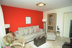 ein Wohnzimmer mit einem Sofa und einer roten Wand in der Unterkunft Chalet am See in Waldsieversdorf