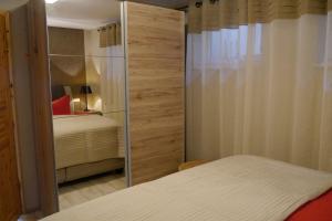 Schlafzimmer mit einem Bett und einer Glasschiebetür in der Unterkunft Chalet am See in Waldsieversdorf