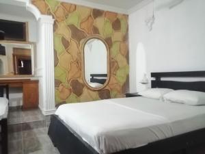 1 dormitorio con 1 cama grande y espejo en hotel avenida53, en Barranquilla