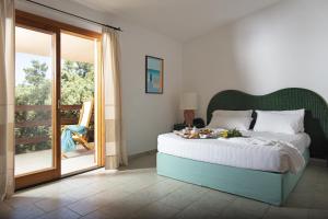 a bedroom with a bed and a sliding glass door at Resort & SPA Le Dune in Badesi