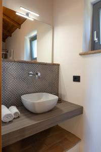 bagno con lavabo a ciotola e specchio di Casa Vespina Agriturismo Biologico a Orvieto