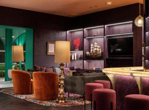 a lobby with a bar and pink chairs at Boutique Hotel Complex Apartment with Hot Tub, Pool & Gym in Wellington
