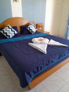 a blue bed with towels and pillows on it at Pailin Hill Hotel Patong in Patong Beach