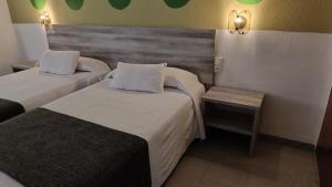 a hotel room with two beds and a bench at Hotel Venta de la Punta in Santa Bárbara