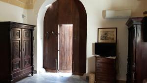 um quarto com uma porta de madeira e uma televisão em Garibaldi 15 em Marsala