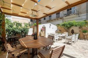 an outdoor patio with a wooden table and chairs at Garibaldi 15 in Marsala