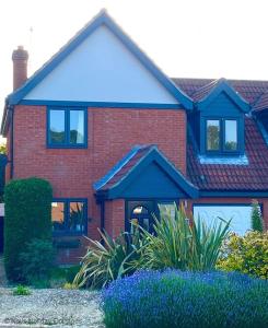 una casa de ladrillo rojo con techo azul en Seaview Retreat en Sheringham