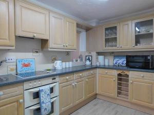 a large kitchen with wooden cabinets and appliances at Seaview Retreat in Sheringham