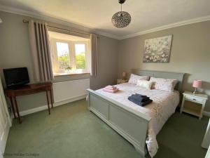 a bedroom with a bed and a television in it at Seaview Retreat in Sheringham