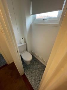a small bathroom with a toilet and a window at Large 2 bedroom house in Wombridge