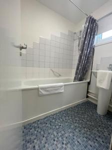 a white bathroom with a tub and a shower at Large 2 bedroom house in Wombridge