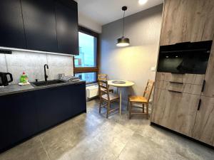 uma cozinha com um lavatório e uma mesa com cadeiras em Apartament Lotnisko Chopina Warsaw Airport em Varsóvia