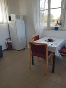 een keuken met een tafel en stoelen en een koelkast bij Csillagmajor in Csabrendek
