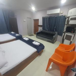 um quarto com duas camas e uma cadeira em Hotel Family Stay em Aurangabad