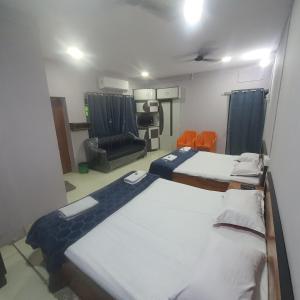 a room with two beds and a living room at Hotel Family Stay in Aurangabad