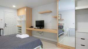 1 dormitorio con 1 cama y escritorio con TV en Peaberry Place - พีเบอร์รี่เพลส en Ban Song Krathiam
